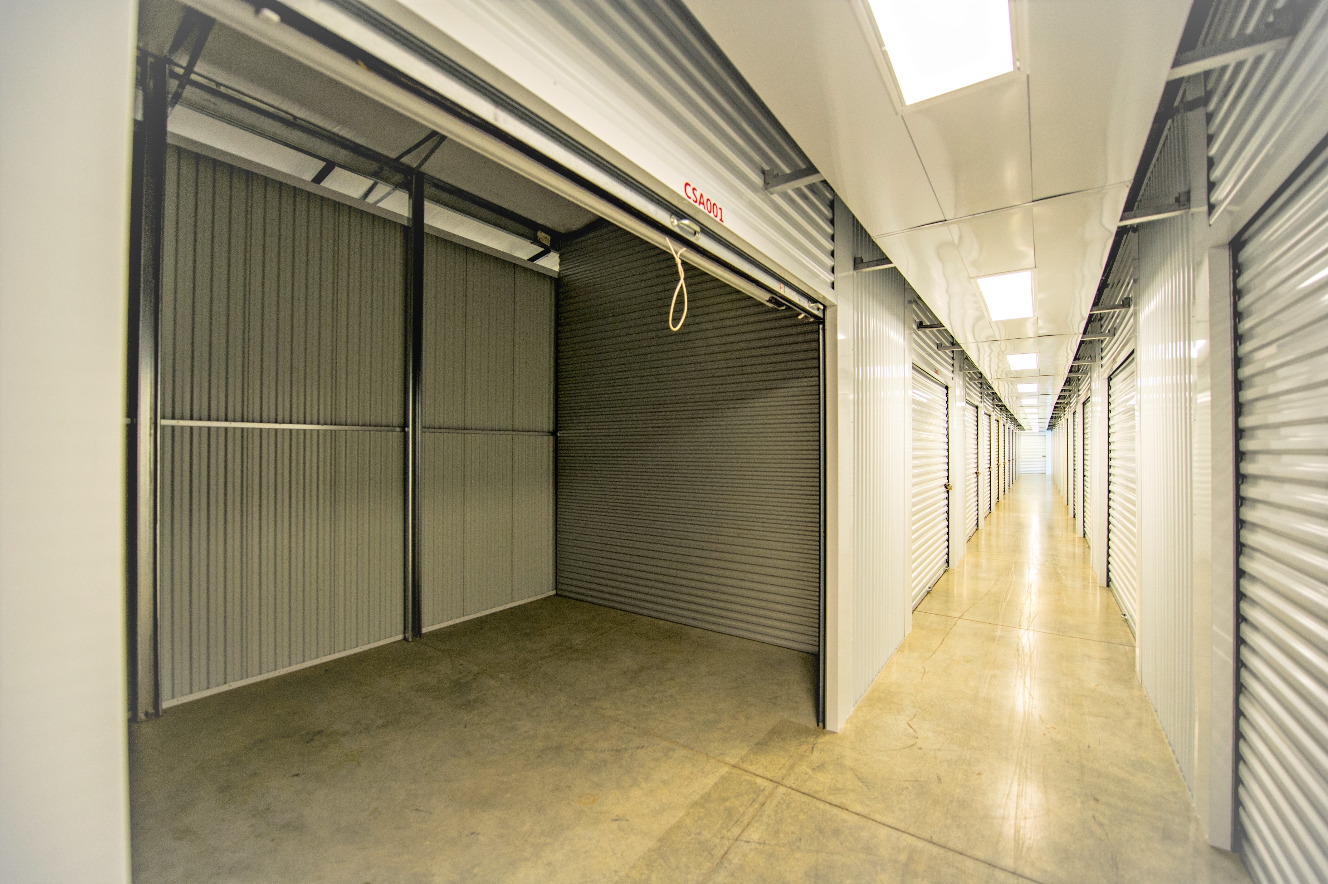 Interior view of climate-controlled storage units at Access Storage, featuring clean, well-lit hallways and white doors.
